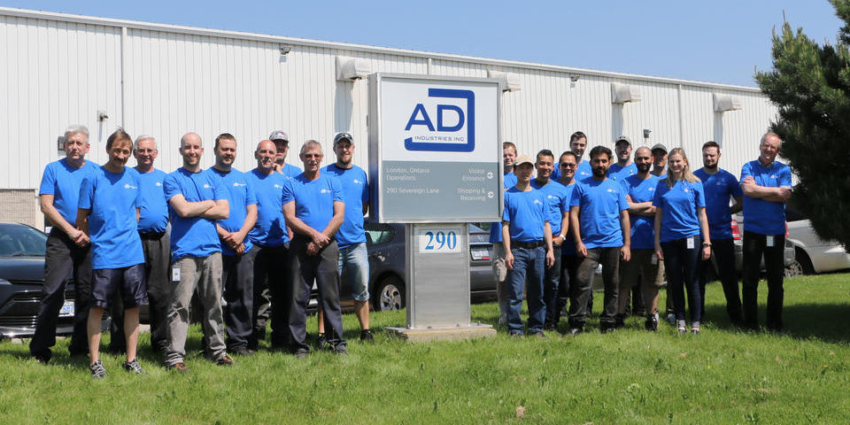 Employees standing infront of the 290 Sovereign Road location of ADJ Industries in London,Ontario.
